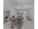 Bright dining area with a glass table, zebra rug, and modern kitchen access at 332 Cocoanut Ave # 503, Sarasota, FL 34236