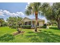 Single-story house with screened porch, lush lawn, and palm trees at 1264 Red Oak Ln, Port Charlotte, FL 33948