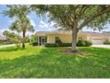 House exterior showcasing a side yard with mature tree and lawn at 1264 Red Oak Ln, Port Charlotte, FL 33948