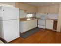 Efficient kitchen featuring white cabinets, wood flooring and appliances at 427 Boxwood Dr, Venice, FL 34285