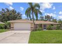 House exterior showcasing a tan facade and a palm tree at 4619 Flint Dr, North Port, FL 34286