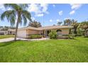House exterior with palm tree and green lawn at 4619 Flint Dr, North Port, FL 34286
