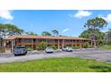 Low angle of condo building exterior with a view of parking and grass at 8 Quails Run Blvd # 6, Englewood, FL 34223