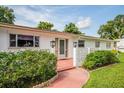 Ranch-style home with a walkway leading to the front door and well-manicured landscaping at 2026 Pine Ter, Sarasota, FL 34231