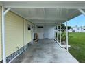 Covered carport area adjacent to the mobile home, providing shade and parking at 406 Trento, Venice, FL 34285