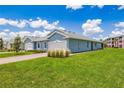 Light blue single-Gathering home with attached garage and well-manicured lawn at 2129 Royal Tern Cir, Punta Gorda, FL 33983