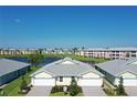 Aerial view of two-story townhouses with lake access and lush landscaping at 2133 Royal Tern Cir, Punta Gorda, FL 33983