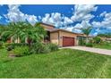 Tan house with red garage door and palm trees at 20193 Pezzana Dr, Venice, FL 34292