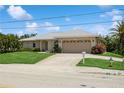 Single-story home with a tan facade and two-car garage at 612 Albee W Rd, Nokomis, FL 34275