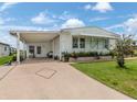 White single-story home with covered carport and landscaping at 281 Harbor Isles Dr, North Port, FL 34287