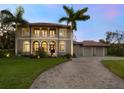 Two story house with a large driveway and palm trees at 1040 Gulf Winds Way, Nokomis, FL 34275