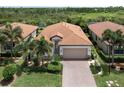 Attractive single-story house with a brick driveway and palm trees at 10079 Crooked Creek Dr, Venice, FL 34293