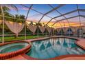 Beautiful screened-in pool area featuring a relaxing hot tub and views of the lush backyard at 2091 Marlin Way, Englewood, FL 34224