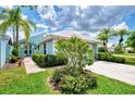 Landscaped exterior of a light blue house with lush greenery at 803 Harrington Lake N Dr # 75, Venice, FL 34293