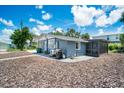 Side view of gray house with screened porch and grill at 4090 Pelican Shores Cir, Englewood, FL 34223