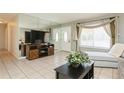 Bright living room features tiled floors and a comfy couch at 18069 Ohara Dr, Port Charlotte, FL 33948