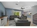 Open living room with grey sectional sofa, a fireplace, and access to a screened patio at 12196 Alachua Ln, Venice, FL 34293