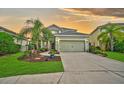 Two-story house with a green exterior, landscaping, and a two-car garage at 12196 Alachua Ln, Venice, FL 34293
