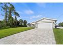 Newly built home with stone accents and a paved driveway at 2676 Cover Ln, North Port, FL 34286