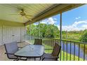 Screened balcony with a table and chairs overlooking a tranquil waterway at 872 Saranac Lake Dr # 202, Venice, FL 34292