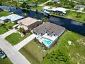 Aerial view of canal front property with pool and nearby homes at 15060 Aquarius Cir, Port Charlotte, FL 33981