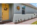 Yellow front door and walkway with landscape lighting at 248 Ibiza Loop, Venice, FL 34292