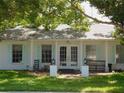 Ranch style home with white exterior, teal shutters, and mature landscaping at 2961 Valencia Rd, Venice, FL 34293