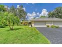 Front view of a tan house with a two-car garage and palm trees at 338 Pembroke Dr # 208, Venice, FL 34293