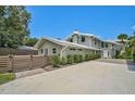 Modern home with gray siding, metal roof and large windows at 412 Cezanne Dr, Osprey, FL 34229