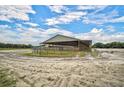 Large covered equestrian barn with multiple stalls at 27000 Harrison Rd, Sidell, FL 34266
