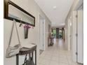 Bright hallway with tile floors, coat rack, and doorways leading to various rooms at 5103 Greencroft Rd, Sarasota, FL 34235