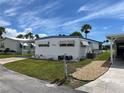 Front view of a charming mobile home with a well-kept lawn at 200 Roma Rd, Venice, FL 34285