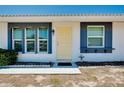 Front view of a single-story house with a yellow door and blue accents at 475 Circlewood Dr # O18, Venice, FL 34293