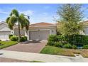 One-story house with tile roof, a two-car garage, and well-manicured landscaping at 12000 Tapestry Ln, Venice, FL 34293