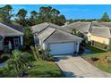 Well-maintained home with a tiled roof, two-car garage, and lush landscaping at 1586 Monarch Dr # 1586, Venice, FL 34293
