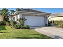 Charming home features a well-manicured lawn and a two-car garage with clean white doors at 1586 Monarch Dr # 1586, Venice, FL 34293