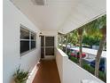 View of condo exterior with covered walkway, lush landscaping, and parking at 760 Village Cir # 212, Venice, FL 34292