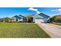 Light blue house with a white garage door and lush lawn at 856 Morgan Towne Pl, Venice, FL 34292