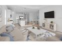 Open living room features a neutral color palette, plush seating, and a large flat-screen TV at 18260 Vizcaya Ct, Venice, FL 34293