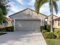 Two-car garage with paved driveway and manicured shrubs at 277 Mestre Pl, North Venice, FL 34275