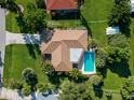 An aerial view showcasing a single-story house, a swimming pool, and spacious green lawn at 424 Baycrest Dr, Venice, FL 34285