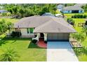 Single-story house with a driveway and American flag at 6470 Mechler St, Englewood, FL 34224