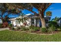 Single story home with white garage door, lush landscaping at 653 Crossfield Cir # 8, Venice, FL 34293