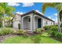Single-story house with a dark front door, grey exterior, and landscaping at 240 Teramo Way, Nokomis, FL 34275