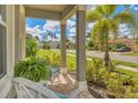 Relaxing front porch with wicker chairs and landscaping at 20318 Minuet Pl, Venice, FL 34293