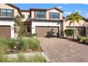 Two-story townhome with brown garage doors and a brick driveway at 12460 Ghiberti Cir # 202, Venice, FL 34293