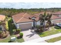 Single-story home with tile roof and two-car garage, nicely landscaped at 10135 Crooked Creek Dr, Venice, FL 34293