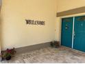 Inviting entryway showcasing a blue double-door, decorative 'Welcome' sign, and stylish brick flooring at 217 Carriage House Ln # 217, Nokomis, FL 34275