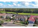 Aerial view of a home with a tile roof, green lawn, and serene water and golf course views at 594 Sawgrass Bridge Rd, Venice, FL 34292