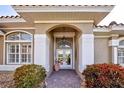 Elegant front entrance with arched doorway and manicured landscaping and brick pathway at 594 Sawgrass Bridge Rd, Venice, FL 34292